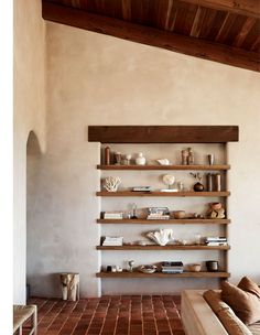 a living room filled with lots of furniture and shelves on the wall next to each other