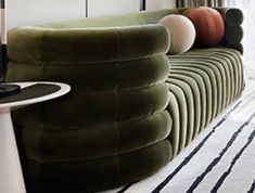 a green couch sitting on top of a white rug