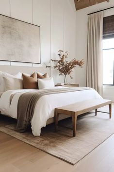 a bedroom with a large bed and wooden flooring in front of a painting on the wall