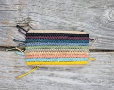 multicolored crochet pouch with tassels on wooden background, closeup