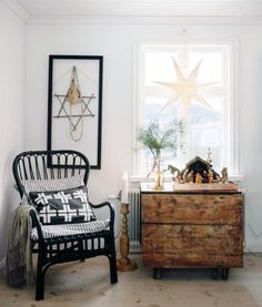 a living room filled with furniture and a star decoration on the window sill next to a dresser