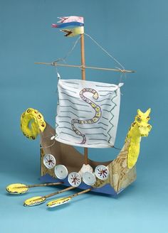 a paper model of a sailboat with animals on it and other items around it