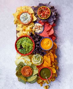 a platter filled with chips, salsa and guacamole