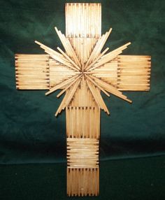 a cross made out of bamboo sticks on a green background