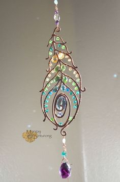 a metal wind chime hanging from the ceiling with beads and crystals on it's side