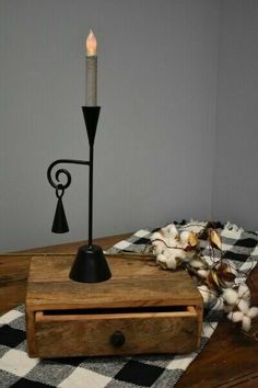 a wooden box with a candle on top of it next to a black and white checkered table cloth