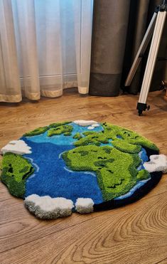 a green and blue area rug on the floor in front of a window with curtains