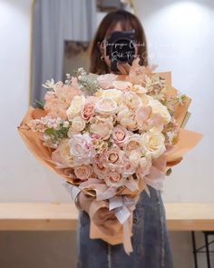 a woman holding a bouquet of flowers in front of her face