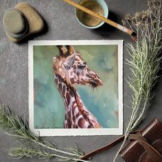 a painting of a giraffe on a table next to some other items and a pair of scissors