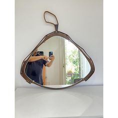 a man taking a selfie in front of a mirror with a clip on it