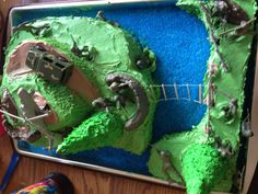 a birthday cake that is shaped like a train on the tracks with green frosting