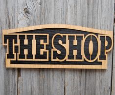 a wooden sign that says heshop on the side of a wood fence,