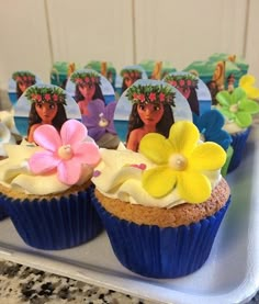 cupcakes decorated with edible flowers on a tray