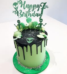 a green and black birthday cake sitting on top of a table