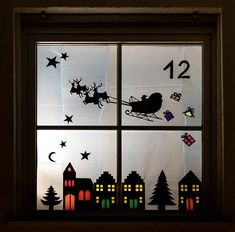 a window decorated with christmas decorations and santa's sleigh in the night