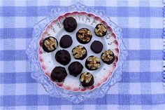 a plate with chocolates and nuts on it sitting on a checkered table cloth