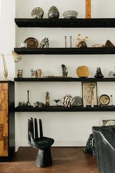 the shelves are filled with decorative items and vases on top of each shelf in this room