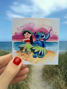 a hand holding up a card with an image of stitch and stitch on it