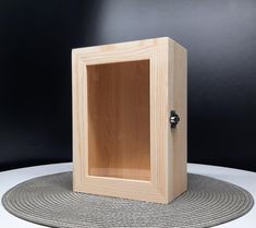 a small wooden box sitting on top of a table next to a round place mat