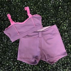 a pair of pink shorts laying on top of green grass