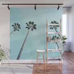 two palm trees against a blue sky wall mural in a room with wooden flooring