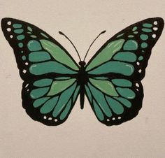 a green and black butterfly sitting on top of a white wall