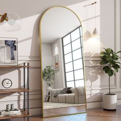 a large gold framed mirror sitting on top of a wooden floor next to a book shelf