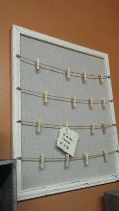 a bulletin board with clothes pins attached to it and a note pinned to the pegs