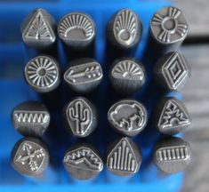 a bunch of metal stamps sitting on top of a blue container