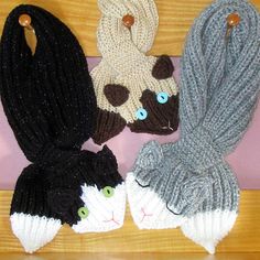 three knitted hats and two cat mittens on a table