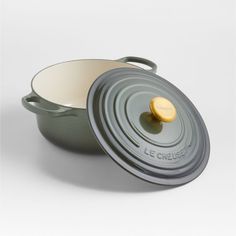 a casserole with a wooden lid on a white background, it appears to be made in france