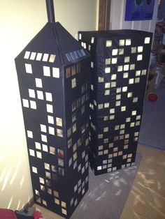 two tall buildings made out of cardboard sitting on the floor