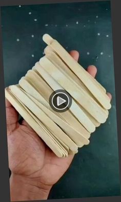 a hand holding a stack of wooden sticks