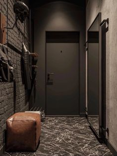 an empty hallway with two doors and a brown footstool in front of the door