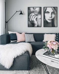 a living room filled with furniture and two pictures on the wall above it's coffee table