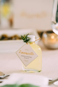 a bottle of lemoncelle sitting on top of a table next to silverware