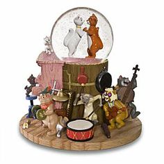 a snow globe with various figurines in it on top of a wooden stand