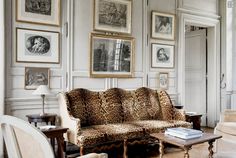 a living room filled with furniture and pictures on the wall