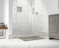 a bathroom with white tile walls and flooring next to a walk - in shower