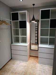 an empty closet with white cabinets and drawers