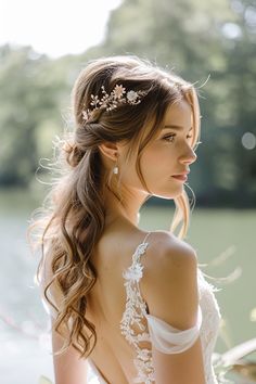 a woman with long hair wearing a wedding dress and holding her hand on her hip