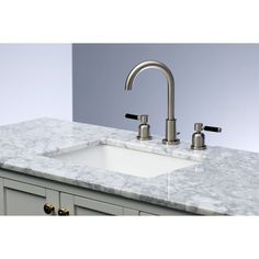 a white sink sitting under a faucet next to a marble counter top in a bathroom