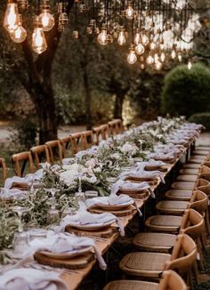 a long table is set up with plates and place settings for an outdoor dinner party