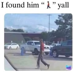 a man walking across a parking lot in front of parked cars and another person standing on the sidewalk