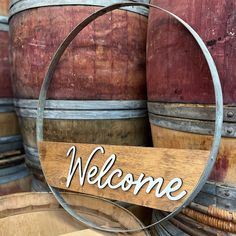 a welcome sign hanging from the side of a barrel