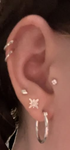 a close up of a person's ear with small white flowers on the side