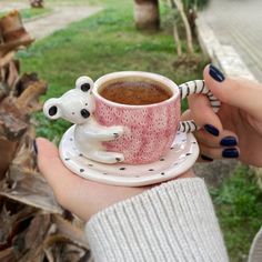 a person holding a coffee cup with two polar bears on the mug and saucer