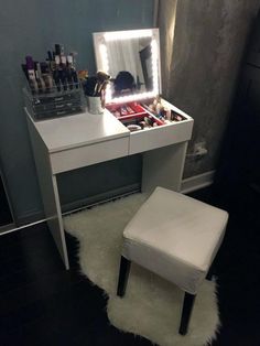 a white vanity with lights on it and a stool