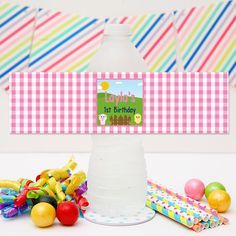 a water bottle with a happy birthday sign on it next to candy and confetti