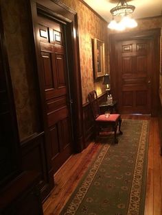 a hallway with wood paneling and an area rug on the floor next to it